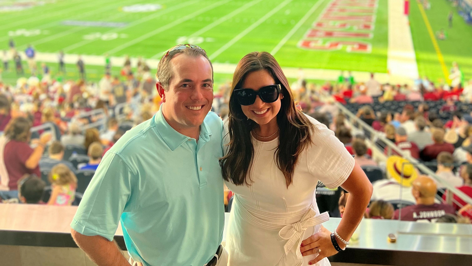 Man and woman standing together at a football game.