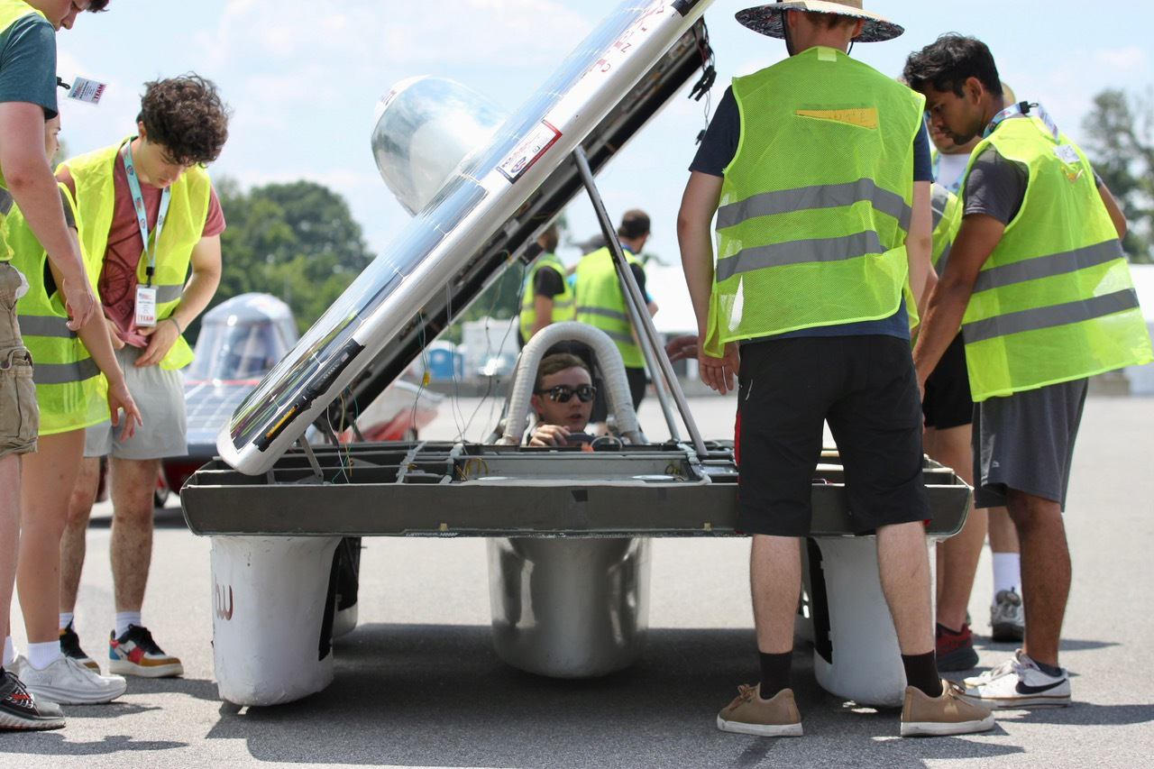 Students surrounding a solar car.