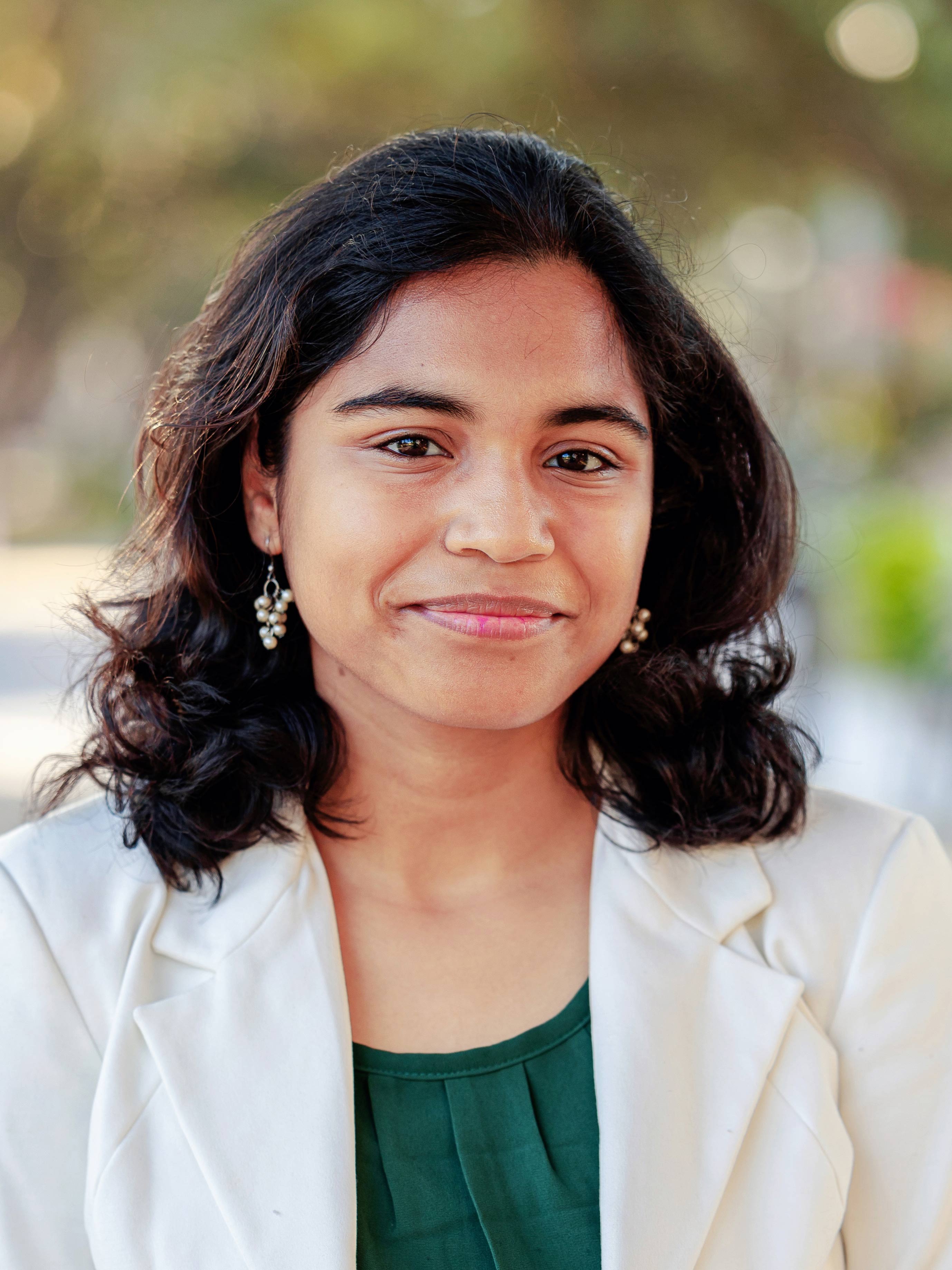 A young woman wearing a white blazer.