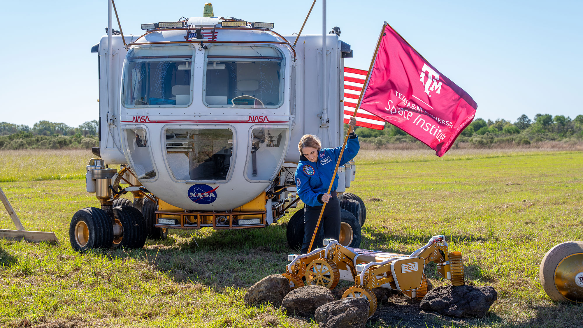 A woman planting a flag in the ground for the Texas A&amp;M University Space Institute