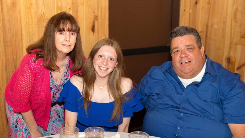 Two women and a man at a table.