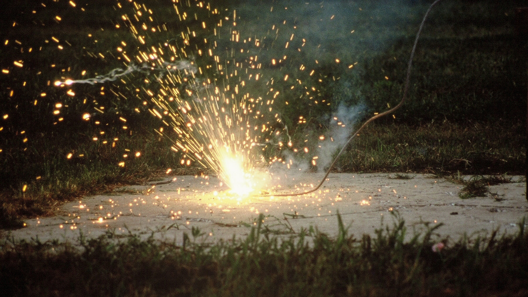 Downed conductor sparking a fire on concrete.