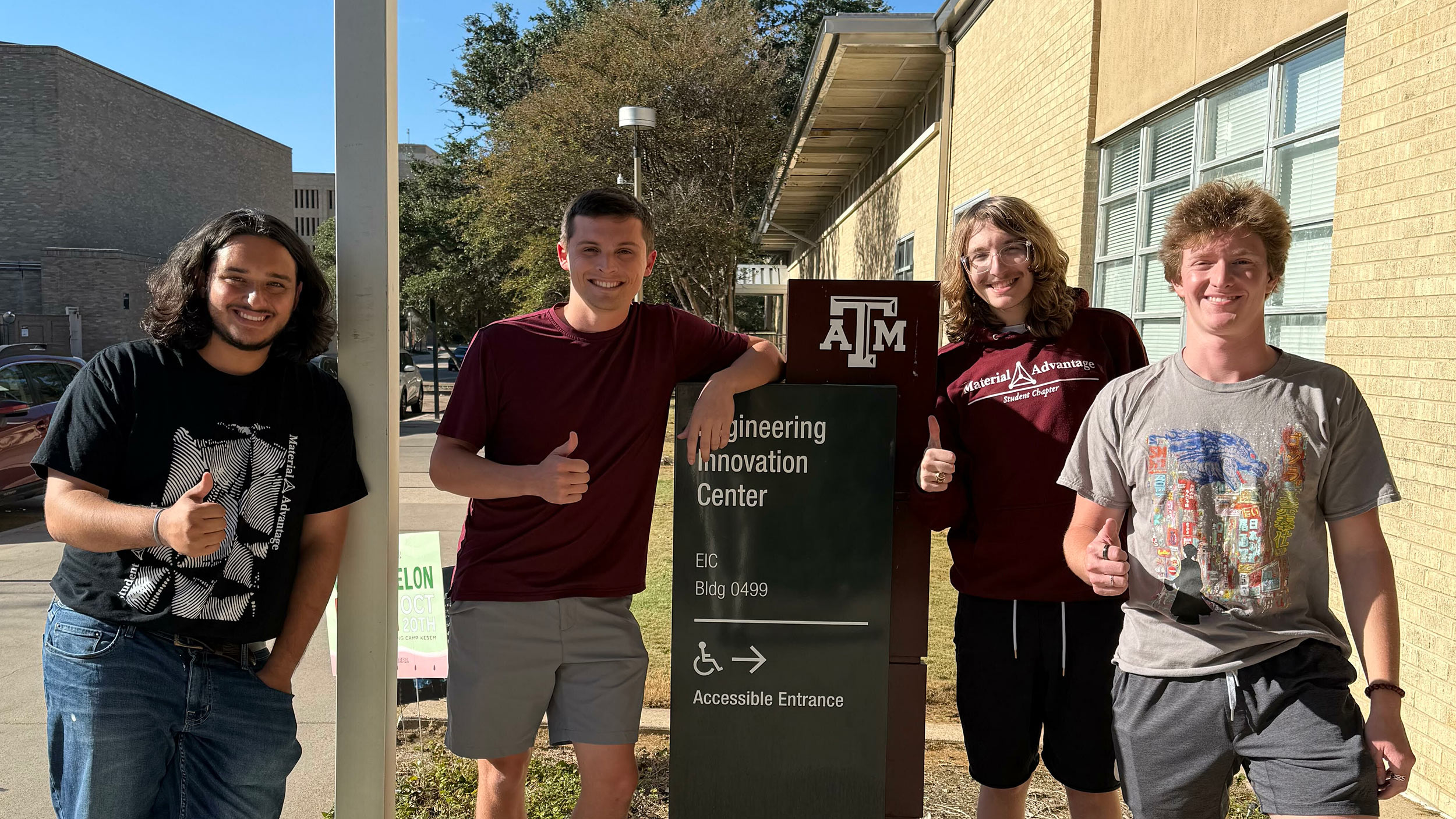 Four students give the thumbs up.