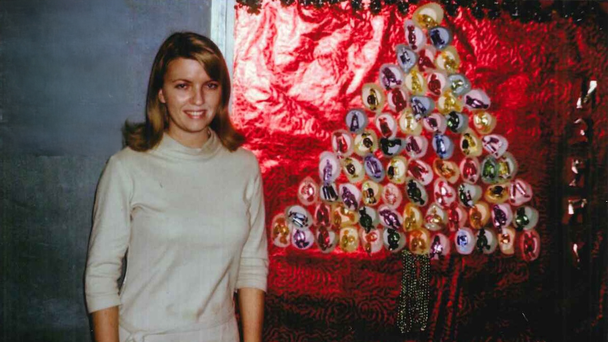 Woman standing next to a holiday display.