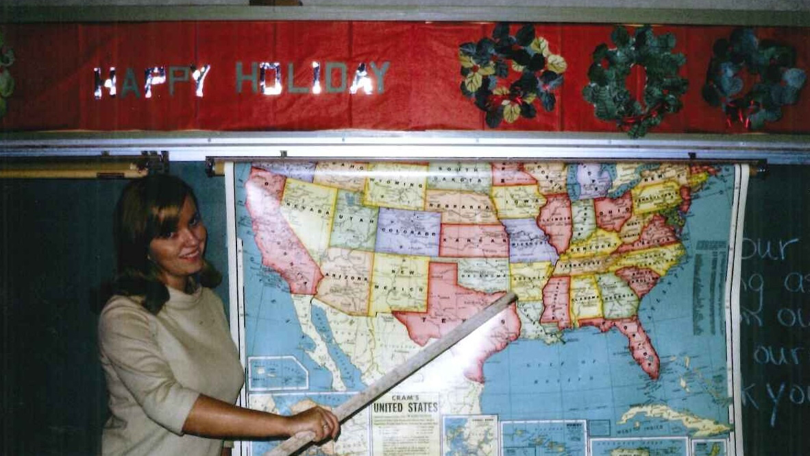 School teacher pointing at a United States map.