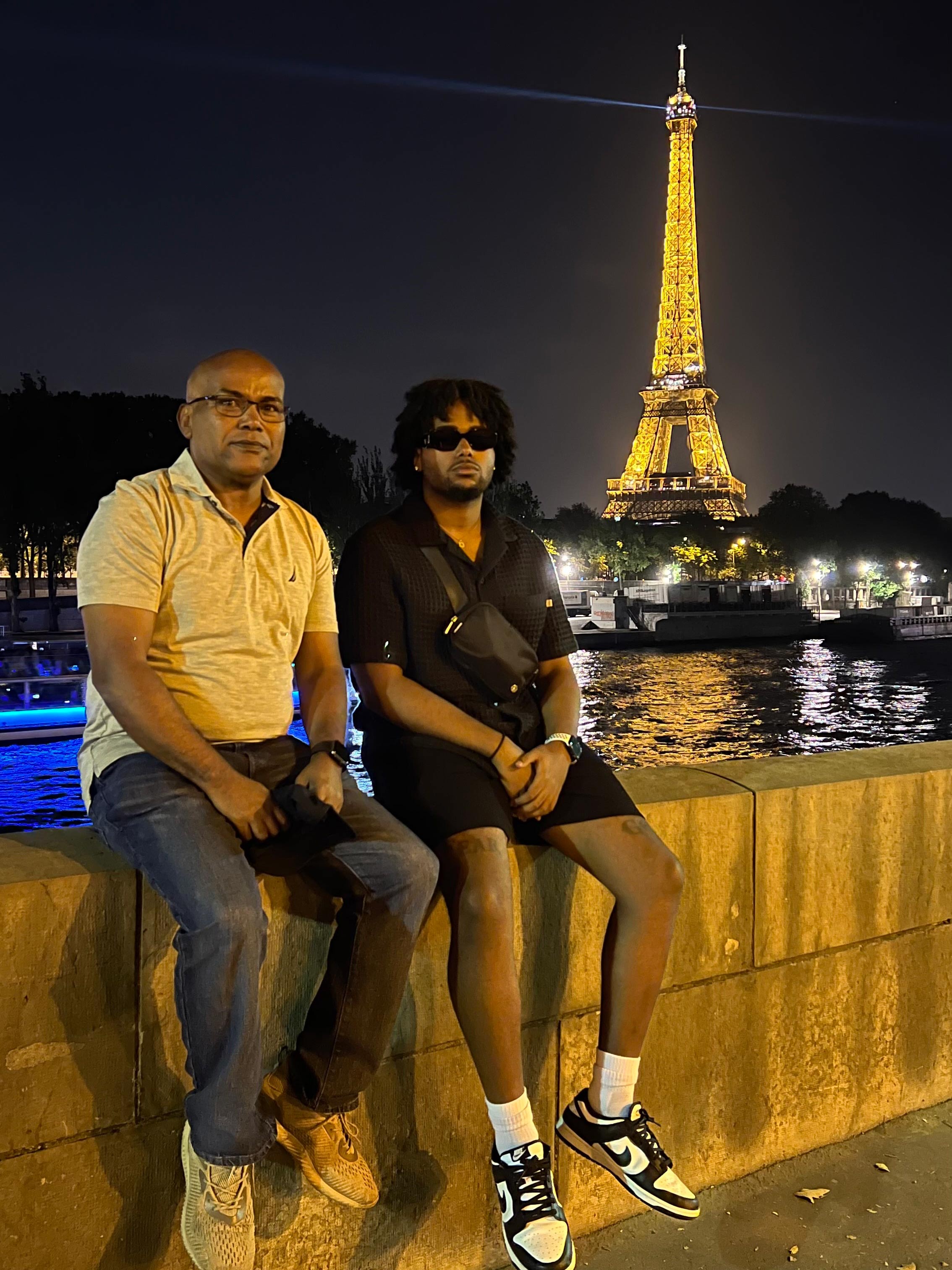 Two men pose in front of a monument.