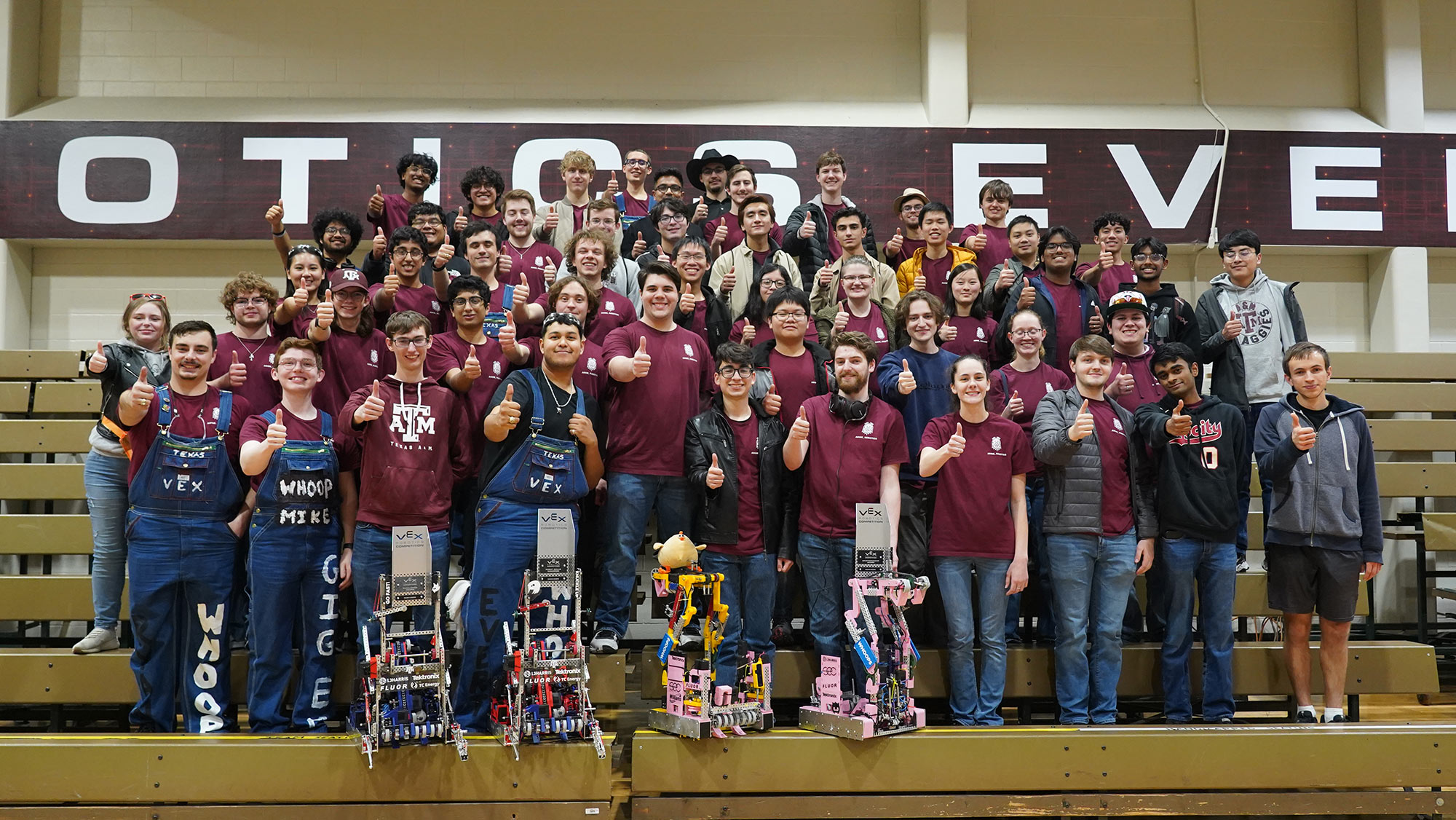 A group of students pose with their robots and awards.