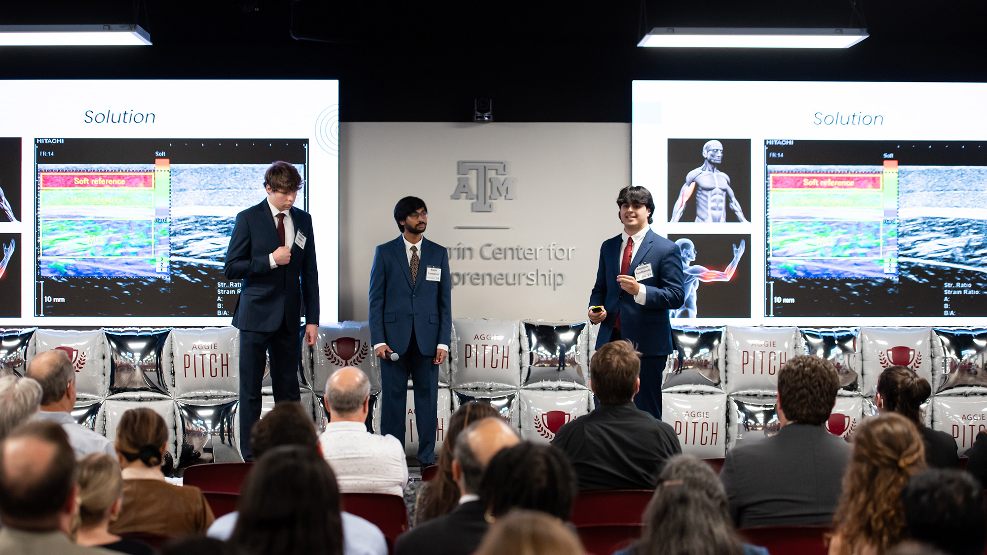 Three people in business attire giving a presentation.