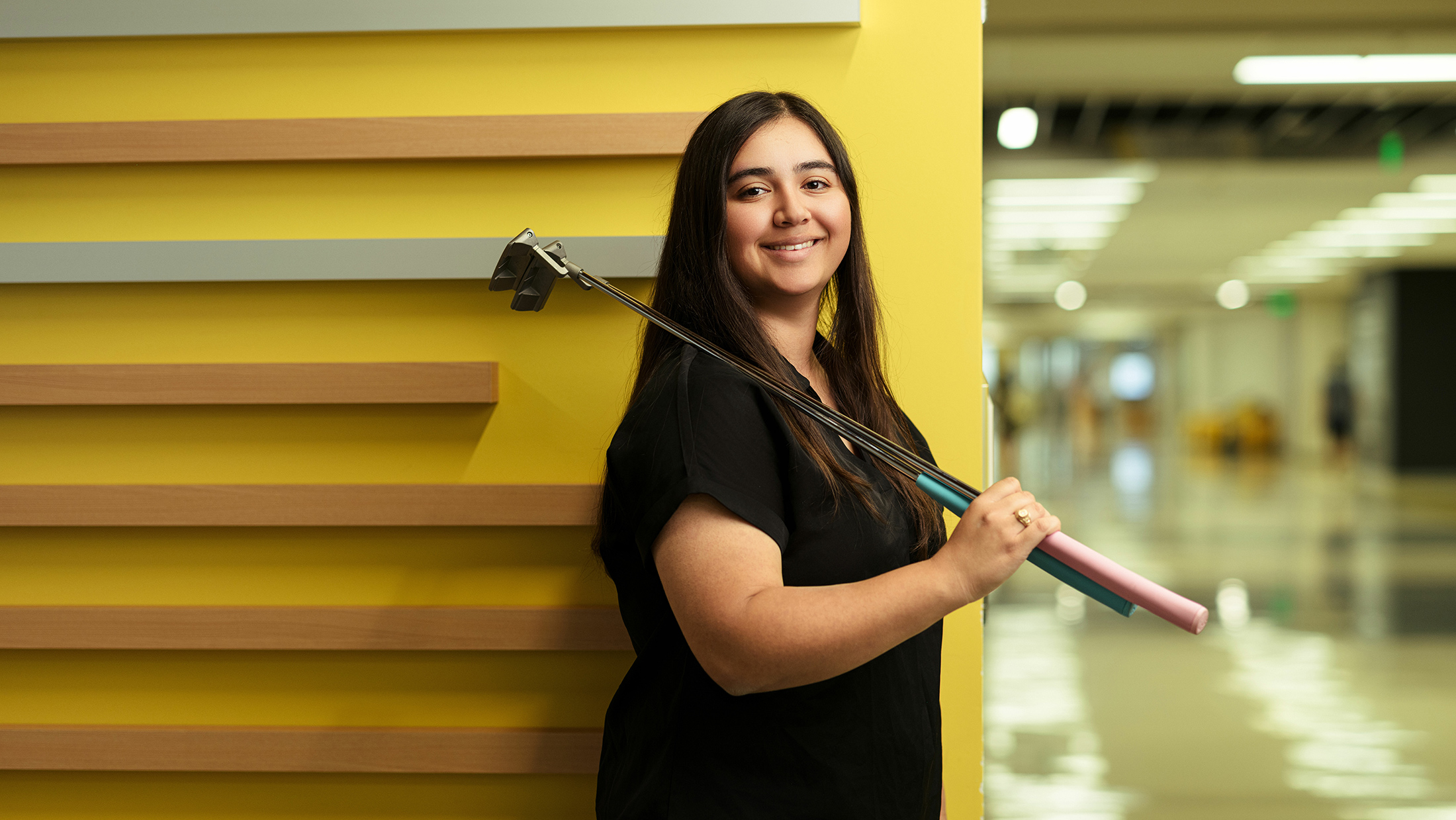 Woman standing with golf club over her shoulder.