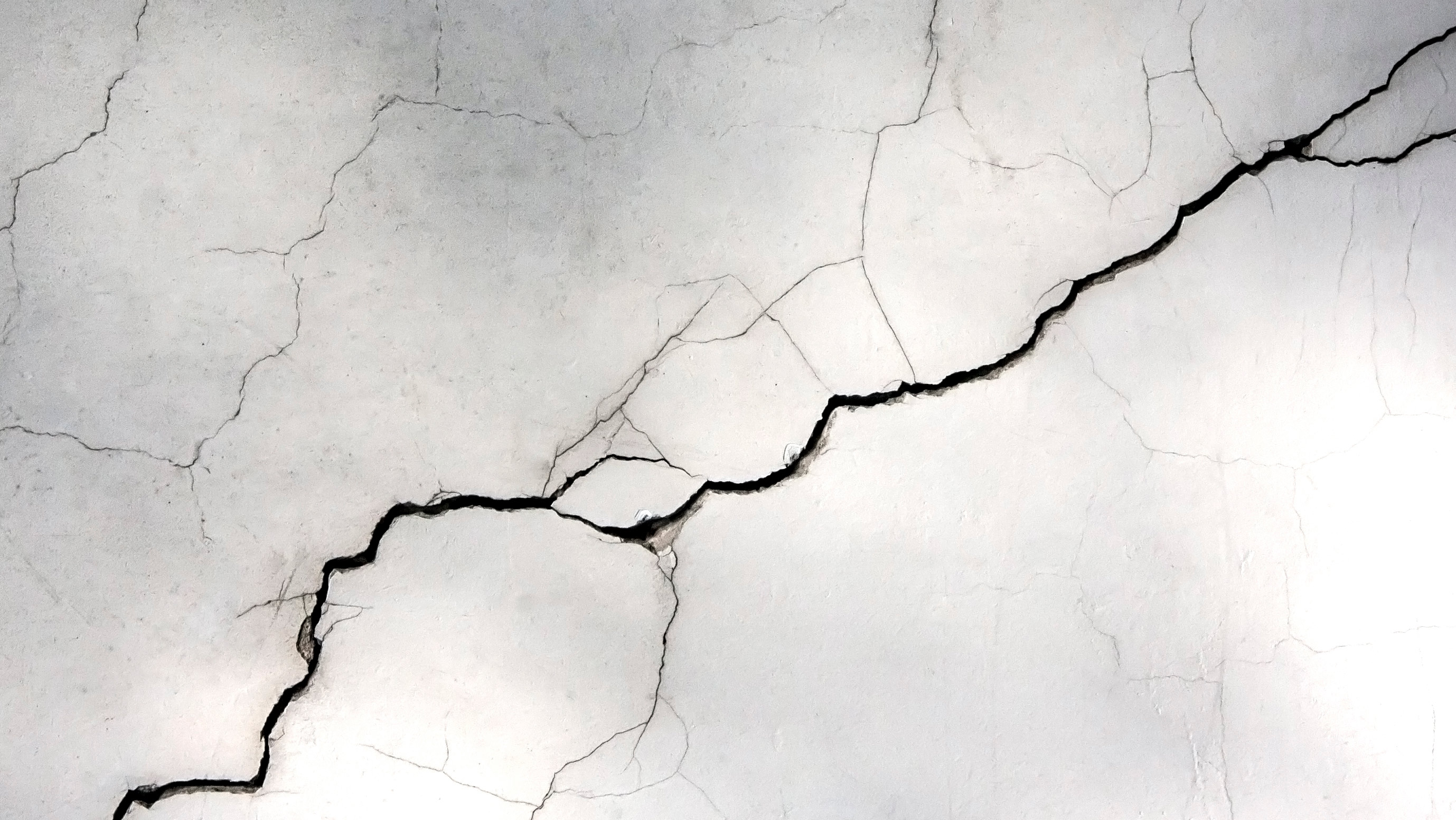 A collage of four rectangles contains two graphics depicting the design of a self-healing concrete system, one photo of lab samples and one photo of cracked concrete.