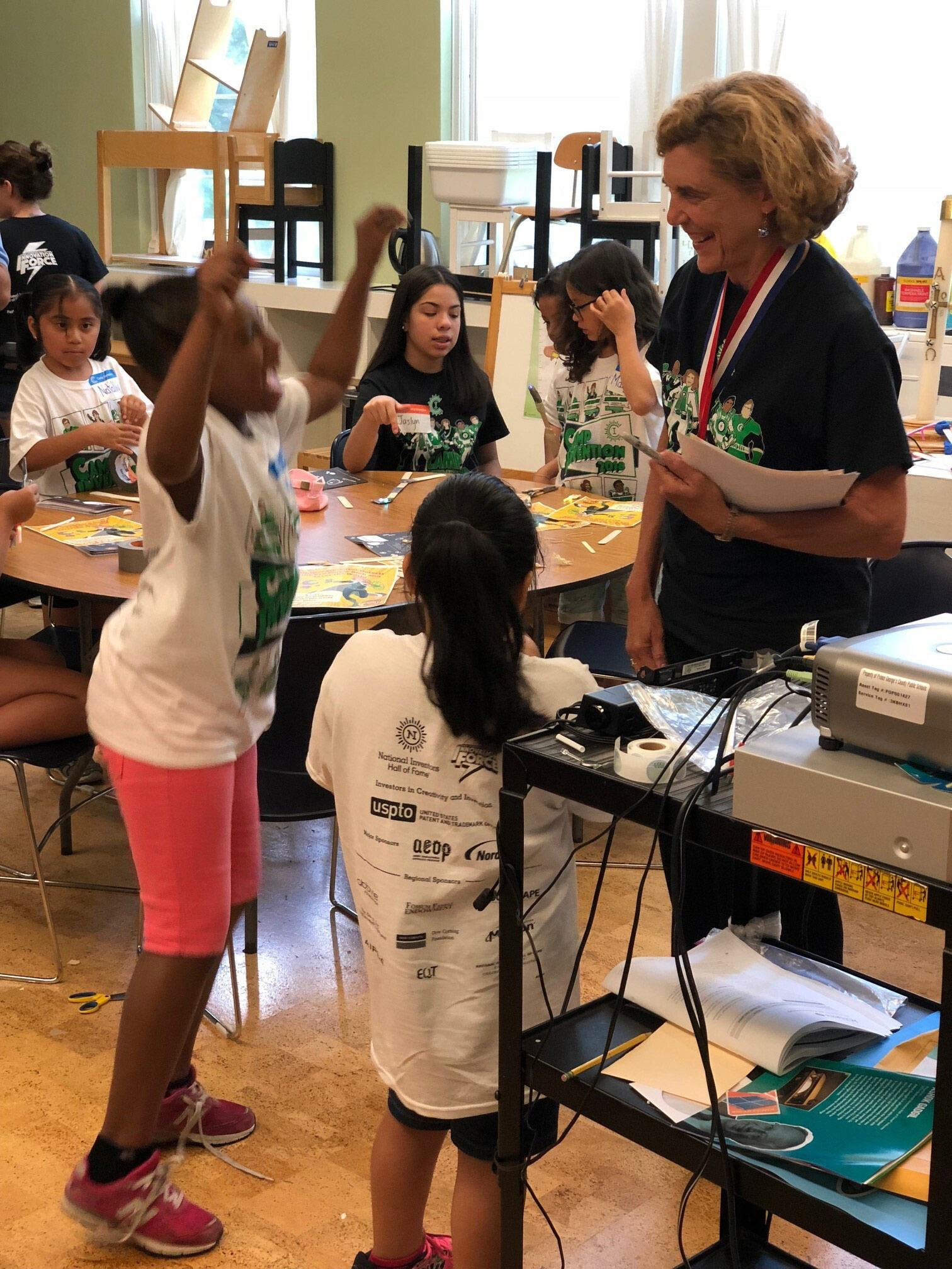 A teacher with a group of students in a classroom.
