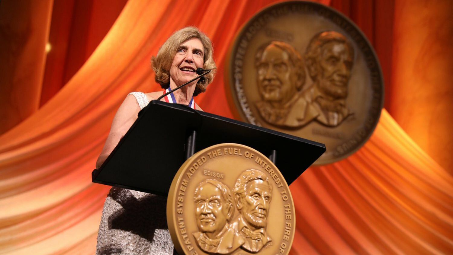 woman giving a speech at a podium.