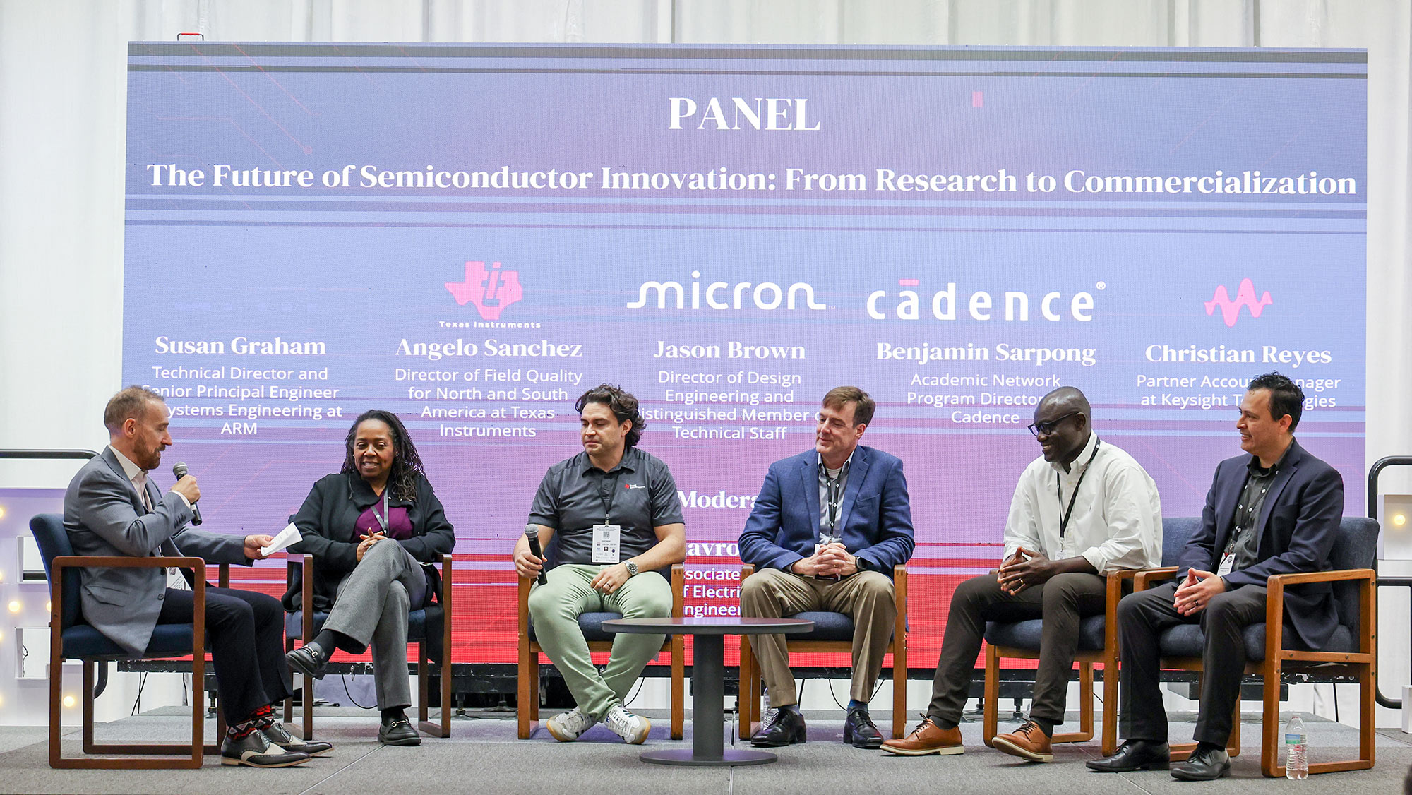 Six people sitting in chairs at a panel discussion.