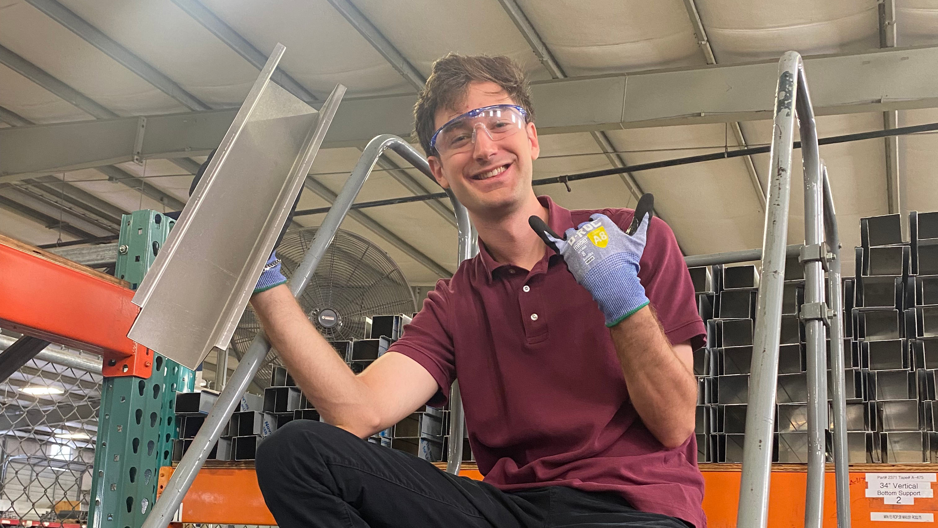 A man sitting smiling on a stair ladder.
