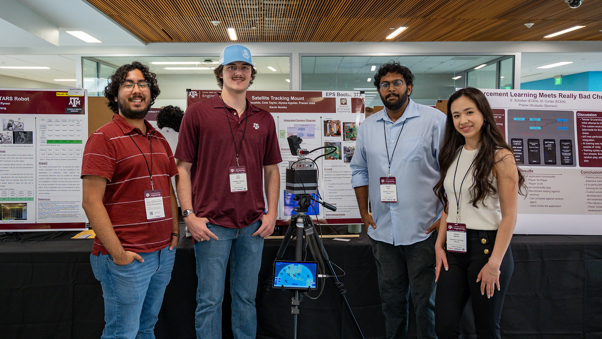 Three men and a woman smile with a prototype.