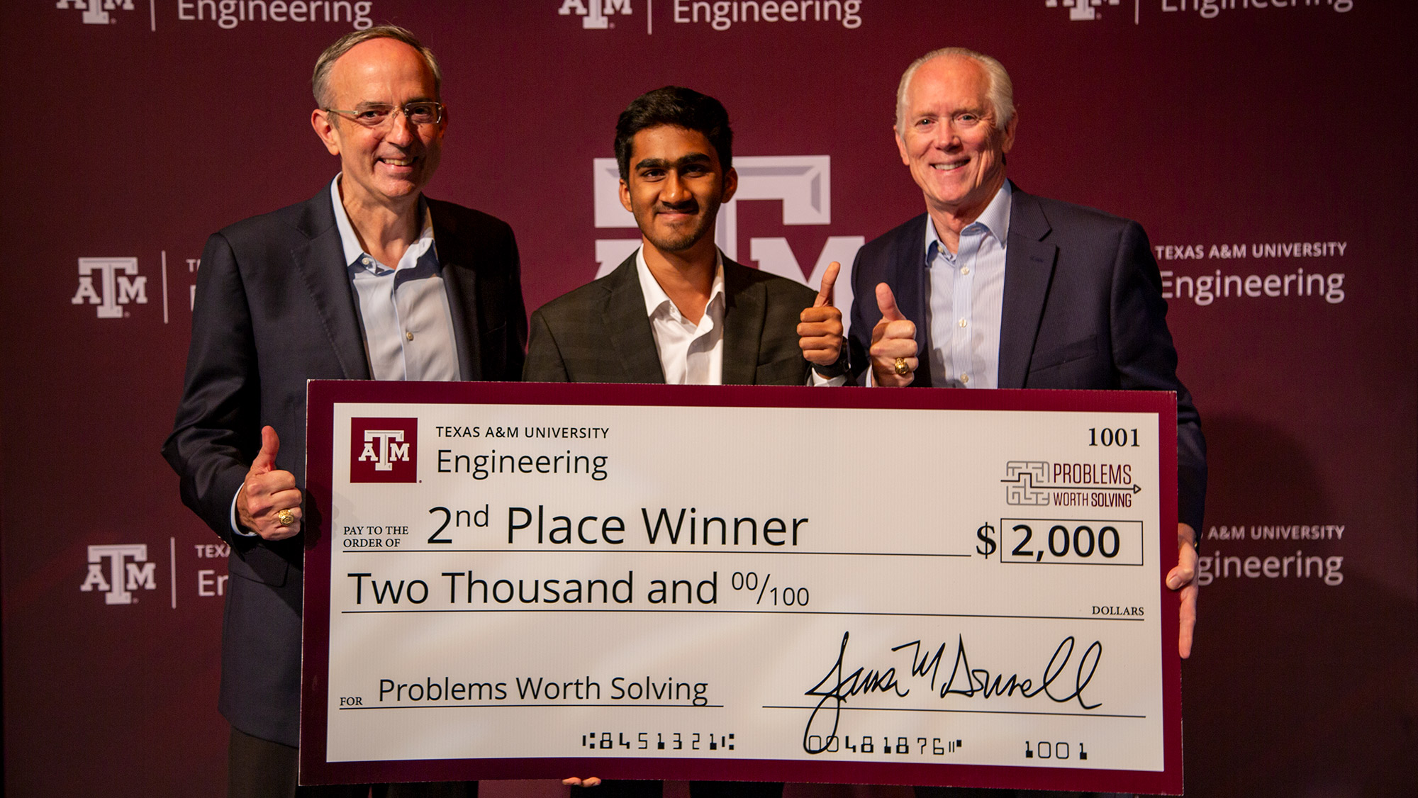 Three people smiling with an oversized check.