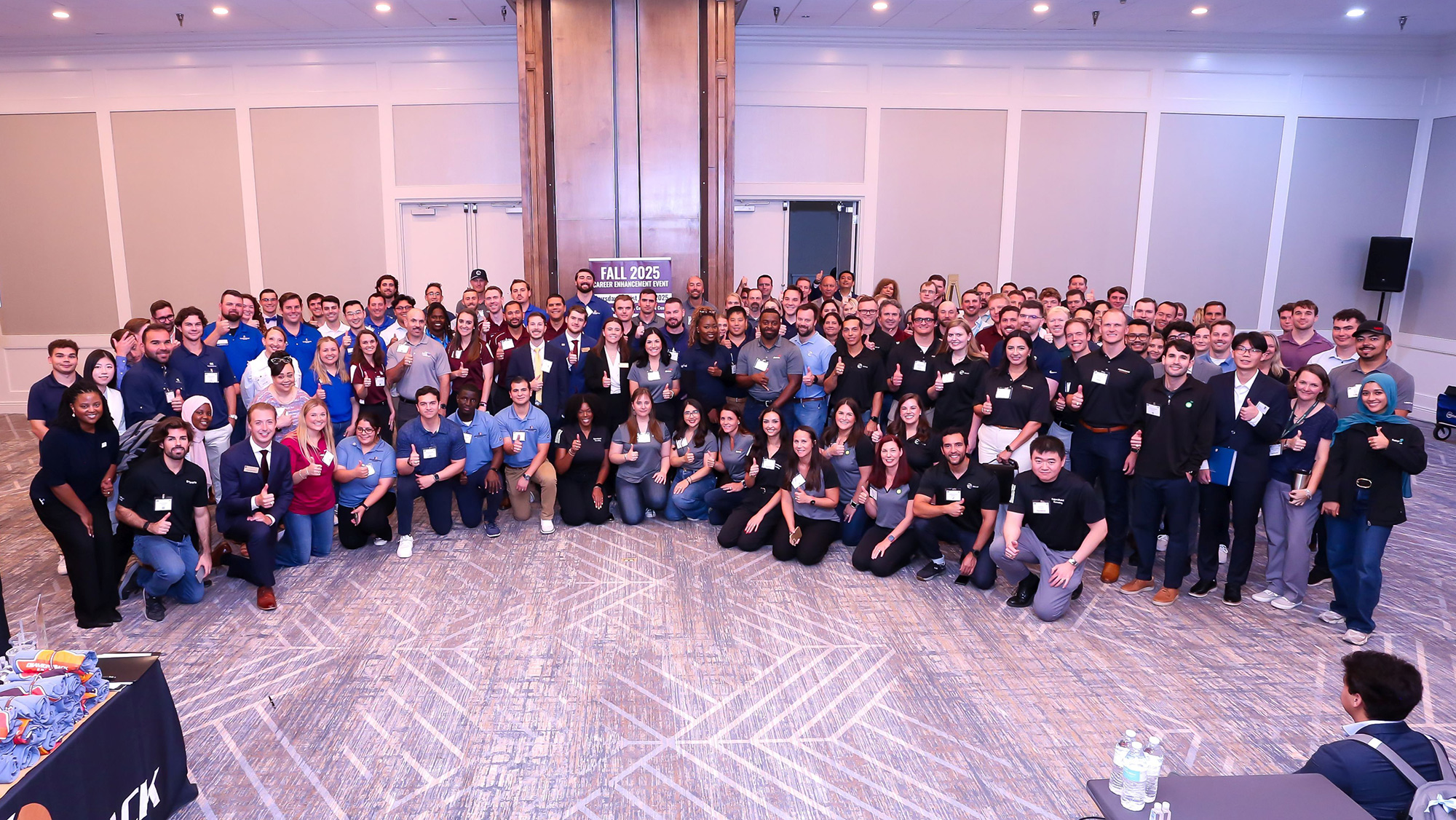 A group of people stand together for a large group photo. 