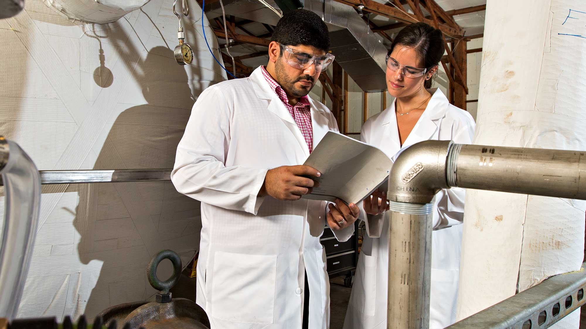 Male and female students reading a manual in the lab.