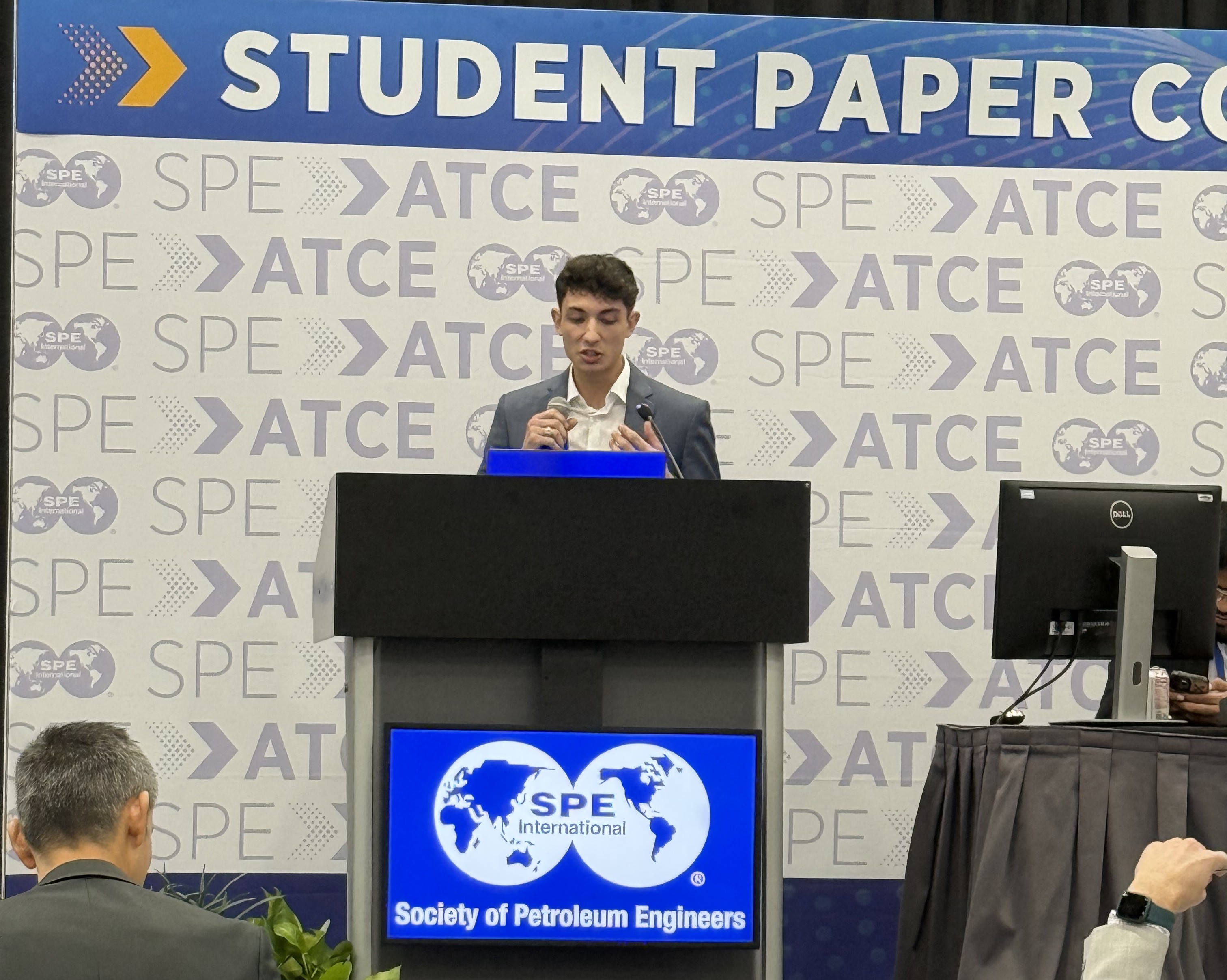 A man stands on a stage presenting.