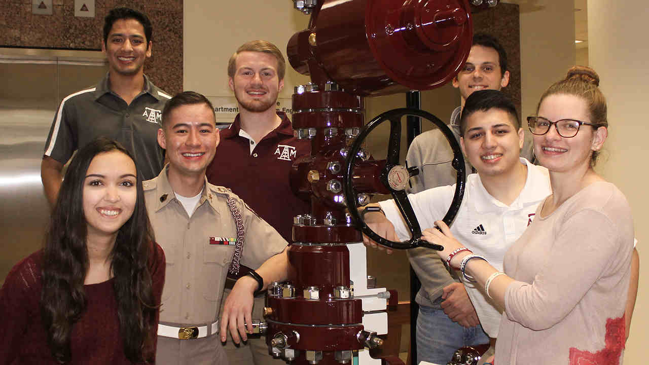 group of petroleum students standing around lobby valve display