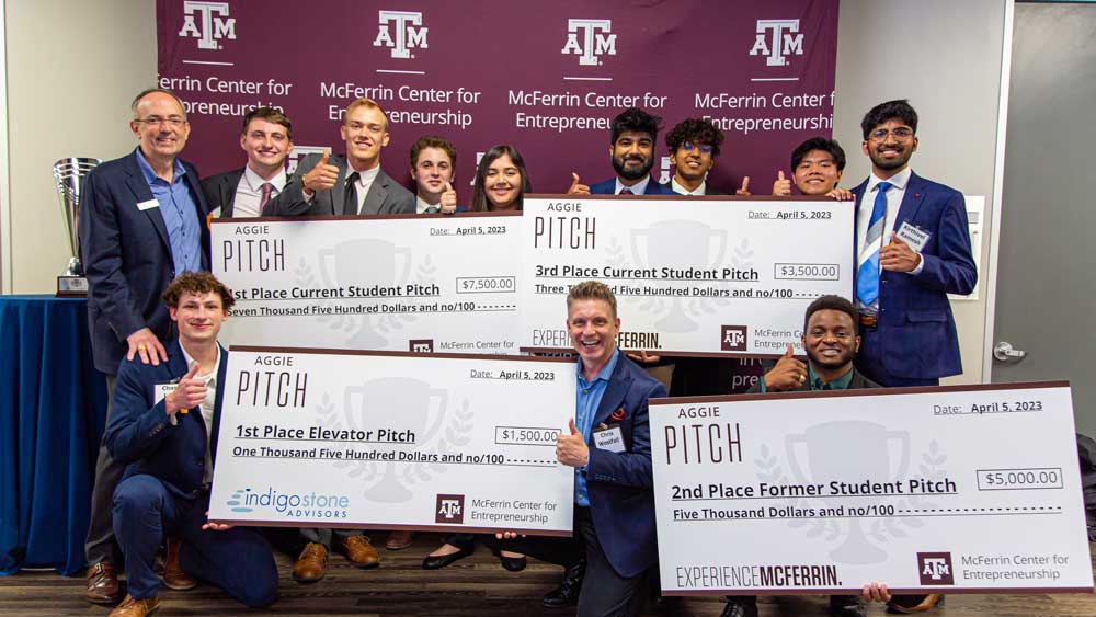 Chris Curran and his students with their large checks at the Mcferrin Center for Entrepreneurship Aggie PITCH contest. 